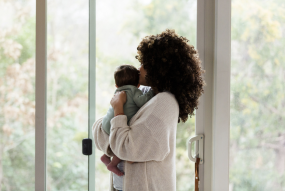 Curly haired woman holding small child