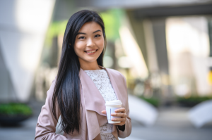 Asian woman with long black hair drinking coffee