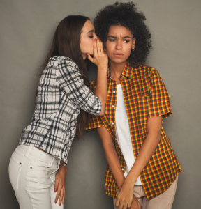 Woman whispering to another woman